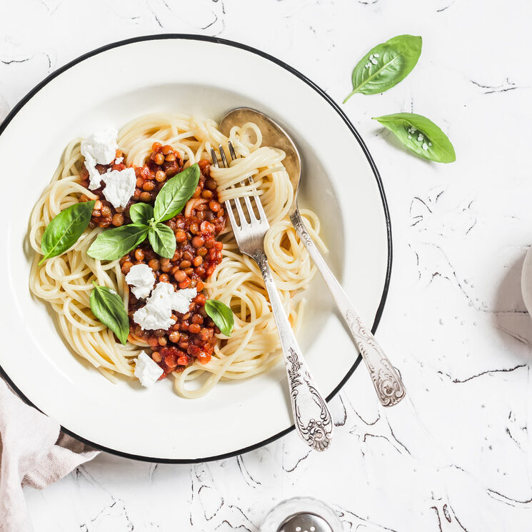 Spaghetti with vegetarian lentil bolognese on a light background. Delicious healthy vegetarian food